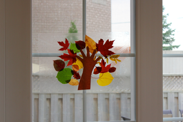 TheInspiredHome.org // Fall Leaf Craft with Toddlers. Make a stained glass tree using contact paper and a variety of autumn leaves.